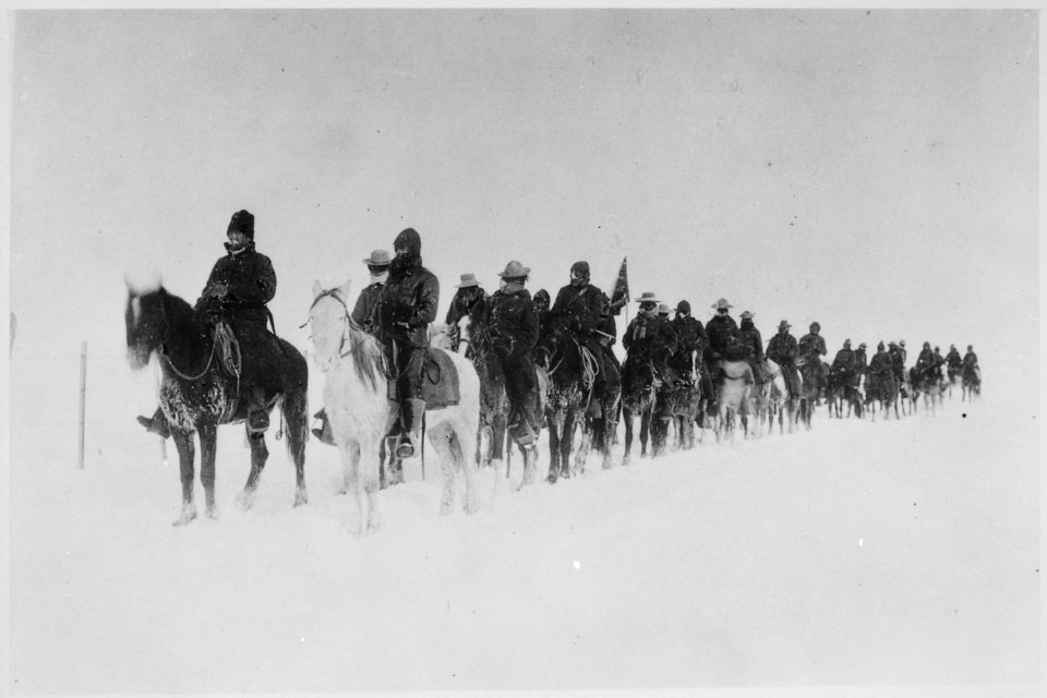 Return of Casey's scouts from the fight at Wounded Knee, 1890-91. Soldiers on horseback plod through the snow - NARA - 531103