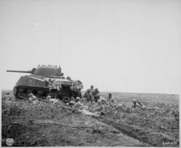 Negro troops of the 24th Infantry, attached to the Americal Division, wait to advance behind a tank assault on the Jap( - NARA - 531254 photo