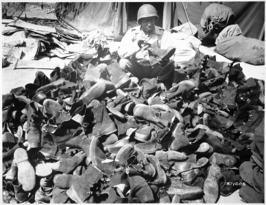 Pfc. Robert Askew...with the 3278th Quartermaster Company, examines overshoes which have been turned in. Overshoes prov - NARA - 531412 photo