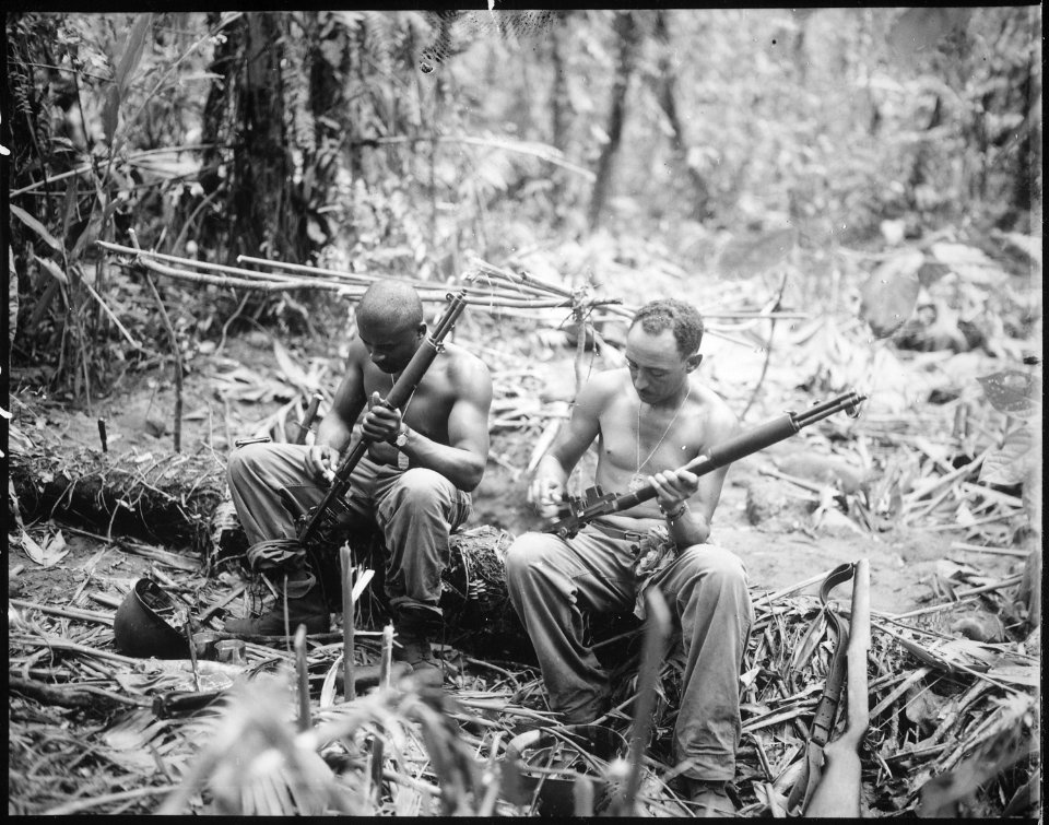 Sgt. John C. Clark...and S-Sgt. Ford M. Shaw...(left to right) clean their rifles in bivouac area alongside the East We - NARA - 531404