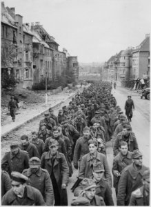 The endless procession of German prisoners captured with the fall of Aachen marching through the ruined city streets to - NARA - 541597 photo