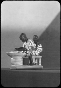 Woman grinding pepper with baby on back - NARA - 558806