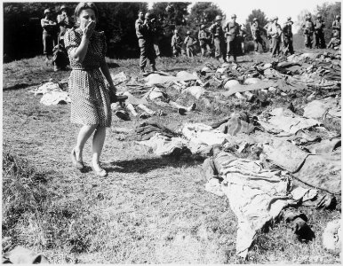 A German girl is overcome as she walks past the exhumed bodies of some of the 800 slave workers murdered by SS guards... - NARA - 531343
