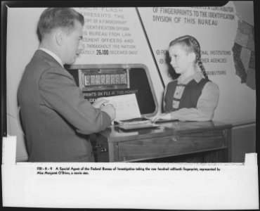 A Special Agent of the Federal Bureau of Investigation taking the one hundred millionth fingerprint, represented by... - NARA - 518186 photo