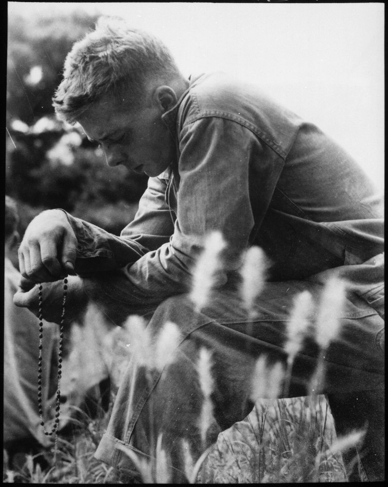 A young Marine finds a moment of quiet and solitude in which to offer up a prayer for the safety of himself and his... - NARA - 532423