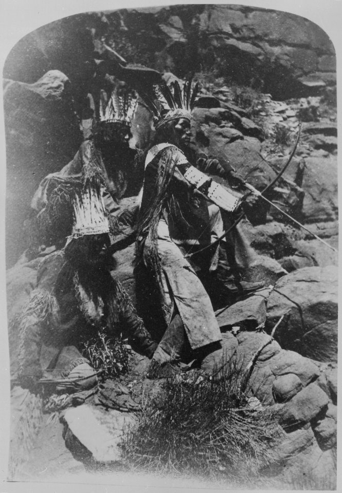 A Paiute drawing his bow and arrow, two others in festive costume, 10-1872 - NARA - 517727