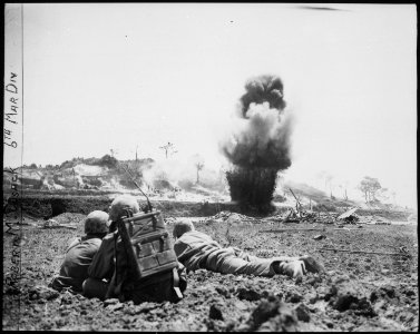 A demolition crew from the 6th Marine Division watch dynamite charges explode and destroy a Japanese cave. Okinawa... - NARA - 532557 photo