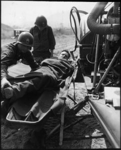 A wounded American is lifted onto a helicopter at the 21st Infantry Regiment collecting station at Painmal, Korea... - NARA - 531402