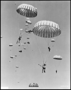 Air dropped by the 437th Troop Carrier Wing, paratroopers of the 187th Regimental Combat Team decend to earth during... - NARA - 542238 photo