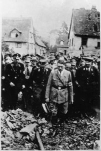 Adolf Hitler, accompanied by other German officials, grimly inspects bomb damage in a German city in 1944, in this... - NARA - 531231
