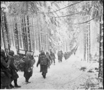 American soldiers of the 289th Infantry Regiment march along the snow-covered road on their way to cut off the Saint... - NARA - 531244