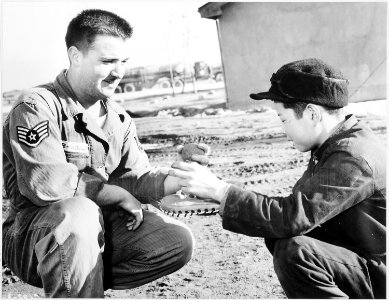 A Korean youth, Kim Pak Soon, is taught one of the fundamental lessons of baseball-get your glove up, and keep the... - NARA - 542323