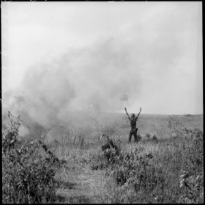 A U.S. Army soldier directs a UH-1 helicopter approaching to pick up injured after a paradrop in South Vietnam. - NARA - 542300