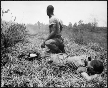 A young American lieutenant, his leg burned by an exploding Viet Cong white phosphorus booby trap, is treated by a medic - NARA - 541863