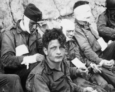 American assault troops of the 16th Infantry Regiment, injured while storming Omaha Beach, wait by the Chalk Cliffs... - NARA - 531187 (cropped)