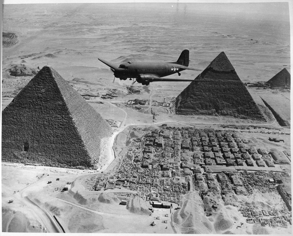 An Air Transport Command plane flies over the pyramids in Egypt. Loaded with urgent war supplies and materials, this... - NARA - 531163