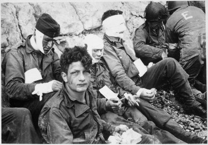 American assault troops of the 16th Infantry Regiment, injured while storming Omaha Beach, wait by the Chalk Cliffs... - NARA - 531187 photo