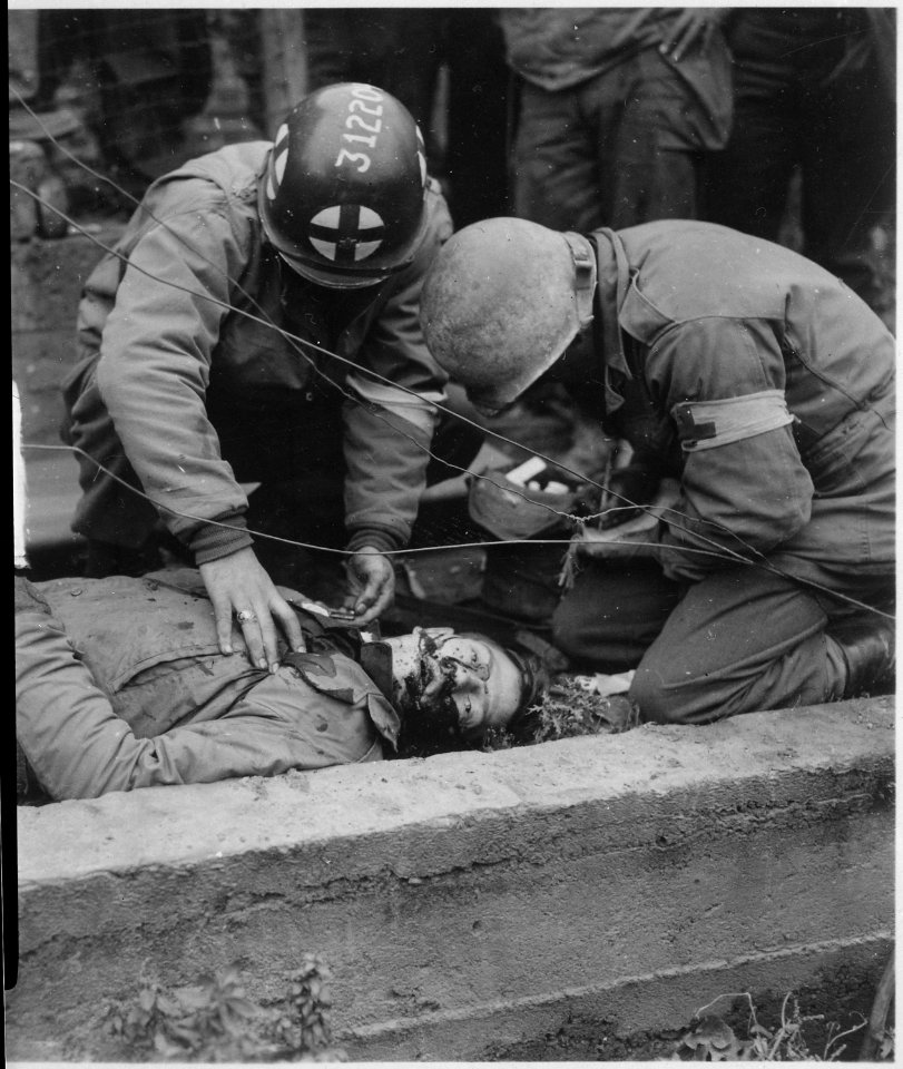 American soldier lies dead in gutter of Schevenhutte, Germany, after being hit by flak from German guns. Medics had... - NARA - 531505