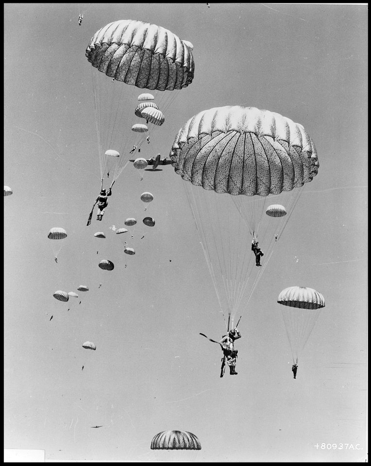 Air dropped by the 437th Troop Carrier Wing, paratroopers of the 187th Regimental Combat Team decend to earth during... - NARA - 542238