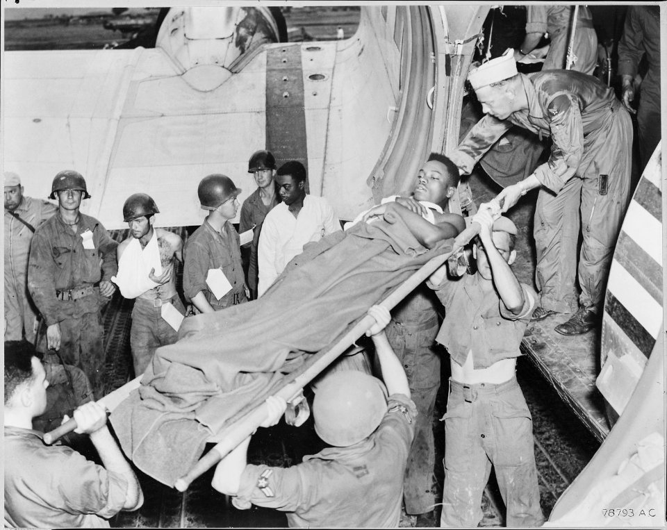 BACK FROM THE FIGHTING FRONT. A group of war-weary wounded soldiers stand by while one of their number is lifted from... - NARA - 542217