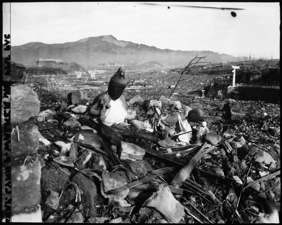 Battered religious figures stand watch on a hill above a tattered valley. Nagasaki, Japan. - NARA - 532564