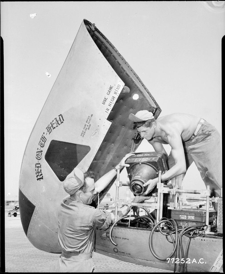 CAMERA TRI-POD, JET PROPELLED. Cameramen mount a giant aerial camera in the nose of a speedy but otherwise unarmed... - NARA - 542195