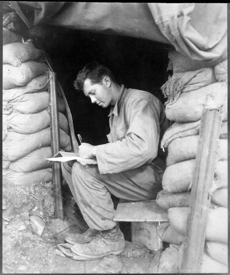 Catching up on his letters to the folks at home during a break in action against the Chinese Communist forces along... - NARA - 531419