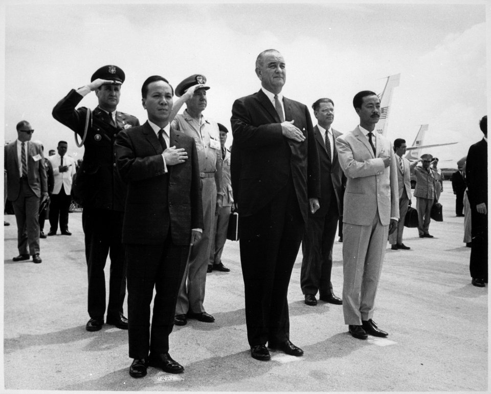 Chairman Nguyen Van Thieu, President Lyndon B. Johnson and Prime Minister Nguyen Cau Ky salute during the playing of the - NARA - 542079