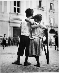 Children in Naples, Italy. Little boy helps one-legged companion across street. - NARA - 520940