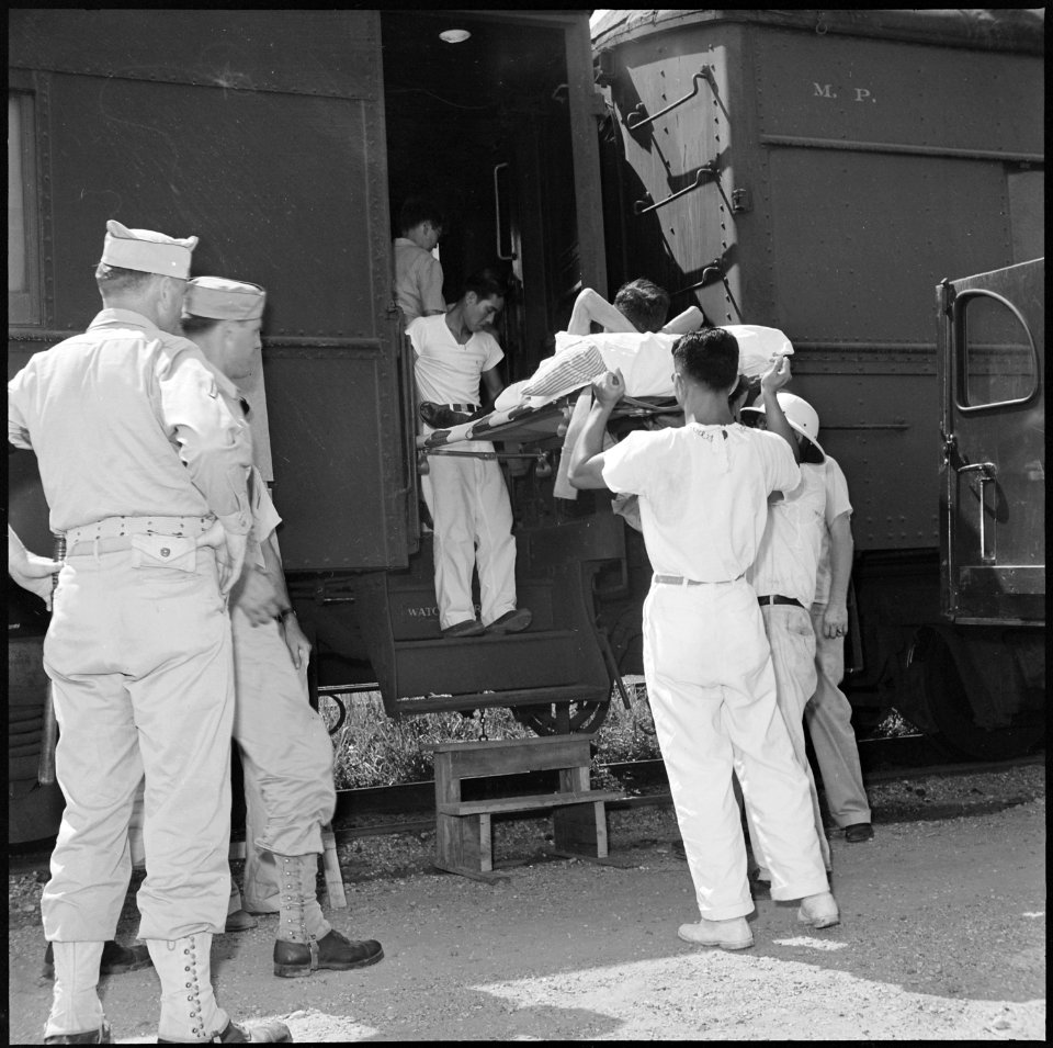 Closing of the Jerome Relocation Center, Denson, Arkansas. A hospital case is loaded by a stretcher . . . - NARA - 539799