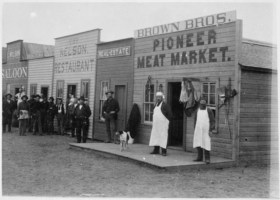 Close-up view of Broadway Street, Round Pond, OkIa. Terr. Shopkeepers and customers pose in doorways. By Kennett, Januar - NARA - 540094