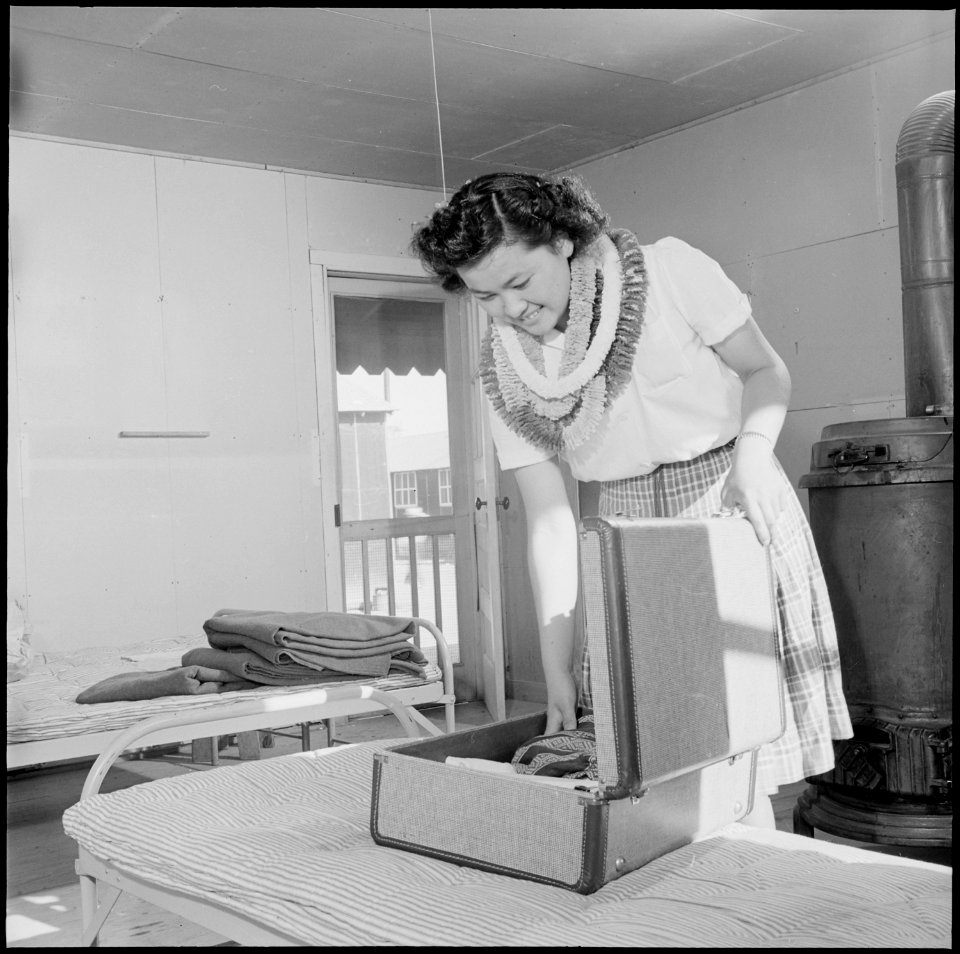 Closing of the Jerome Relocation Center, Denson, Arkansas. Mitzi Matsunaga packs her dresses just p . . . - NARA - 539753