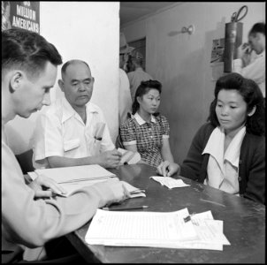 Colorado River Relocation Center, Poston, Arizona. Evacuees waiting in line inside the administrati . . . - NARA - 539894