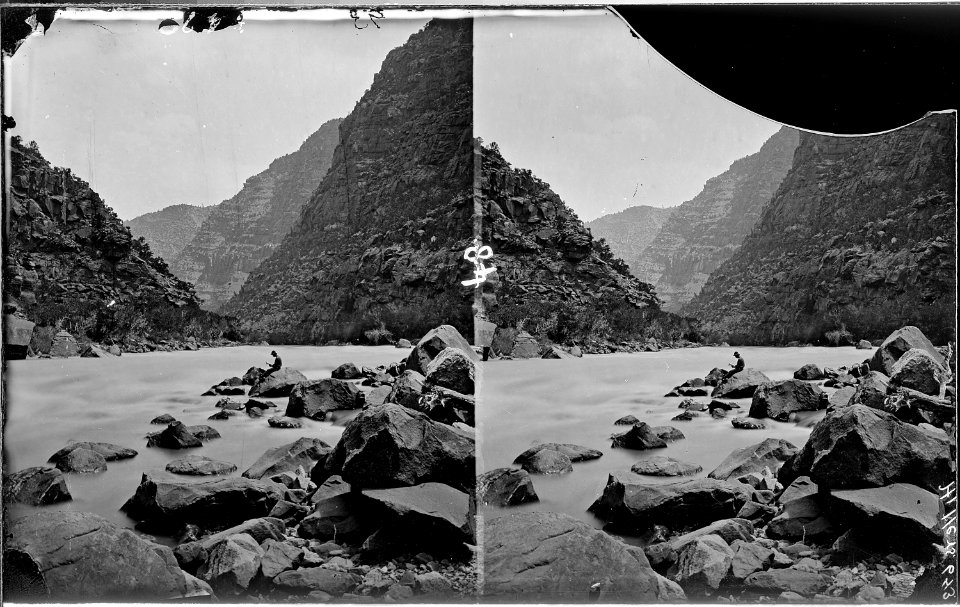 Colorado River. Cataract Canyon, Clem Powell reading while sitting on a boulder in the river. See - NARA - 517890