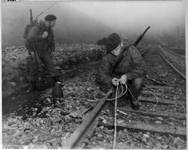Commandoes of the 41st Royal British Marines plant demolition charges along railroad tracks of enemy supply line... - NARA - 520790