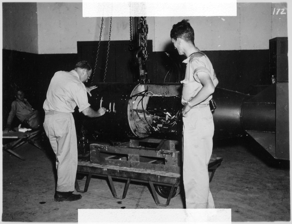 Comdr. A.F. Birch, numbering LB (Little Boy) unit L-11, before loading on trailer in Assembly Bldg. ^1. Unit L-11 was... - NARA - 519395