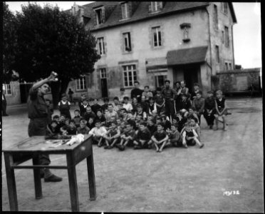 Corporal Paul Opperer, New York City, amuses a group of French children who have taken refuge at a church near... - NARA - 531208