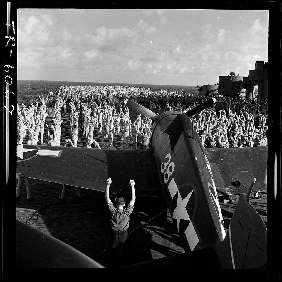 Crew of USS Yorktown (CV-10), performs morning calisthenics amid F6Fs while enroute to attack Jap island fortifications. - NARA - 520926