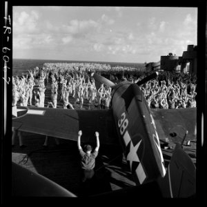 Crew of USS Yorktown (CV-10), performs morning calisthenics amid F6Fs while enroute to attack Jap island fortifications. - NARA - 520926