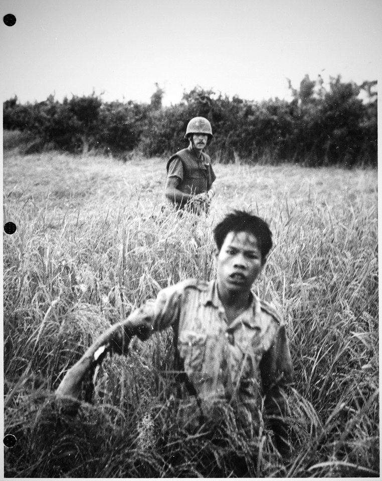 Corporal Atchley (Long Beach, CA), a squad leader of Company B, 1st Battalion, 9th Marines, guards a Viet Cong as he... - NARA - 532434