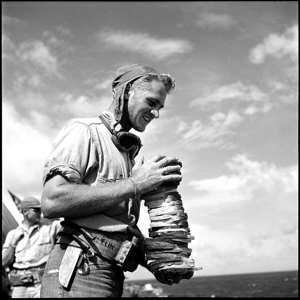 Crewmen loaded down with sandwiches on board USS Monterey (CVL-26), D-day on Saipan. - NARA - 520860