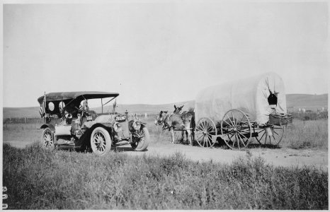 Covered wagon with jackrabbit mules encounters an automobile on the trail near Big Springs, Nebr. By A. L. Westgard, 191 - NARA - 513358