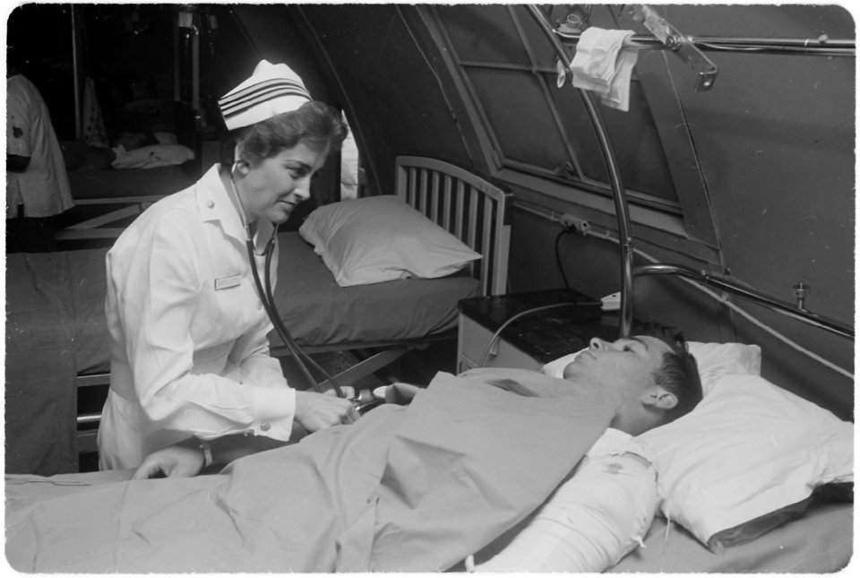 Da Nang, South Vietnam...United States Navy nurse Lieutenant Commander Joan Brouilette checks the condition of Pfc.... - NARA - 558531