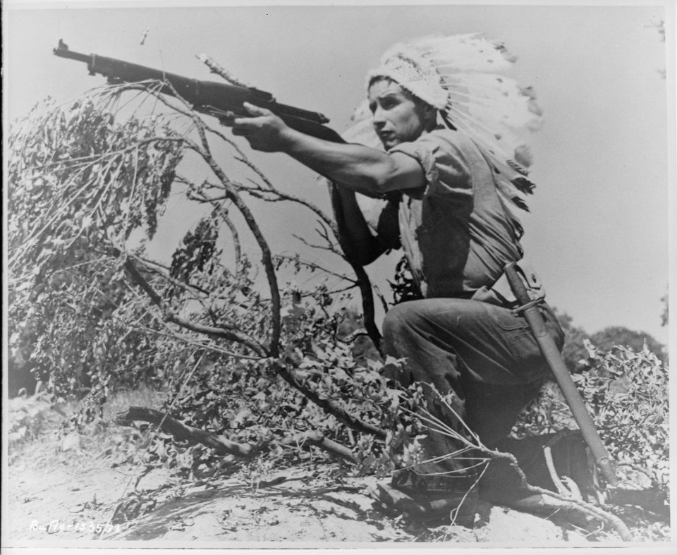 Dan Waupoose, a Menomini chief, full-length, kneeling with a rifle and wearing a feathered headdress, Algiers, Lousiana, - NARA - 520636