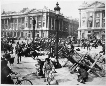 Crowds of Parisians celebrating the entry of Allied troops into Paris scatter for cover as a sniper fires from a... - NARA - 531206