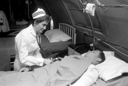 Da Nang, South Vietnam...United States Navy nurse Lieutenant Commander Joan Brouilette checks the condition of Pfc.... - NARA - 558531 photo