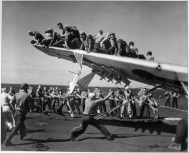 Crash of TBM ^11, VC-69, in port catwalk of USS BOGUE. ^11 being raised from catwalk. - NARA - 520652