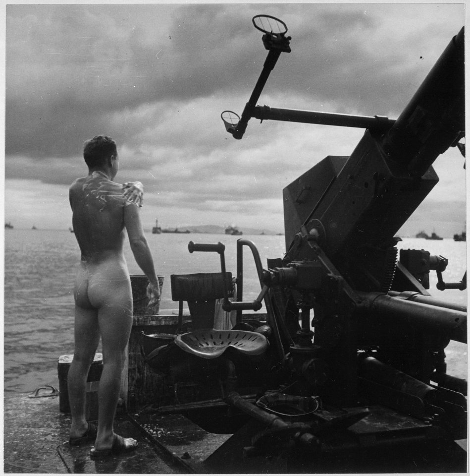 Crewman of a motor torpedo boat covering himself with soap prior to dive over side of ship in the Philippines. - NARA - 520917