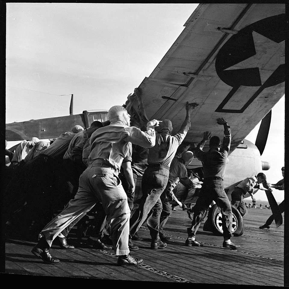 Ens. V.A. Prather, in charge of flight deck crews, energetically directs crewmen aboard USS Lexington (CV-16), as... - NARA - 520766