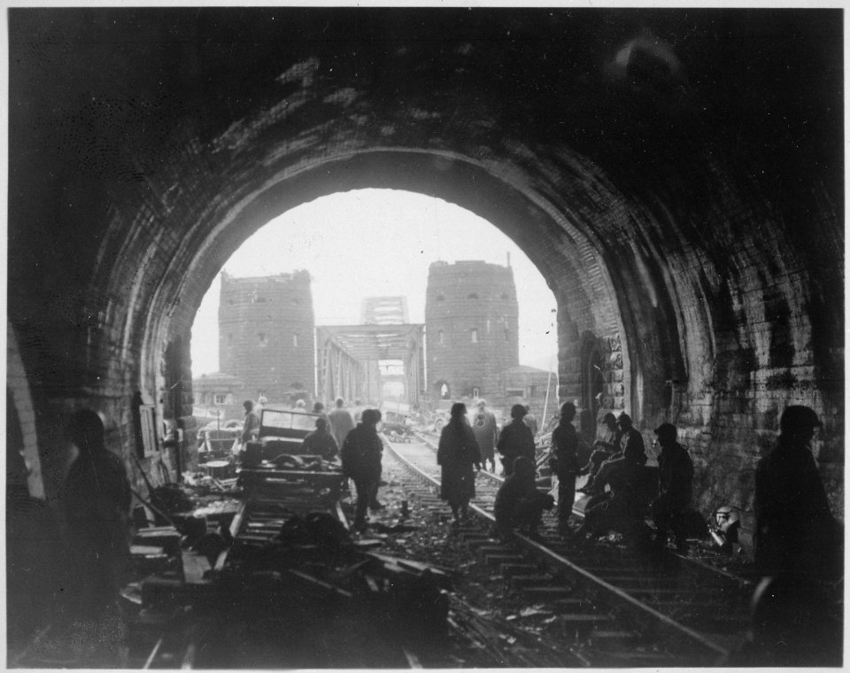 First U.S. Army men and equipment pour across the Remagen Bridge, two knocked out jeeps in foreground. Germany. - NARA - 531252